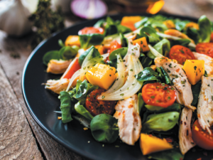 To meet nutrient needs without exceeding protein needs, consume small portions of lean proteins along with vegetables, fruits, and healthy fats (like the plant oil-based dressing on this salad).